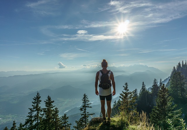 Standing confidently on top of a staircase, looking toward a bright horizon with warm light symbolizing success and growth.